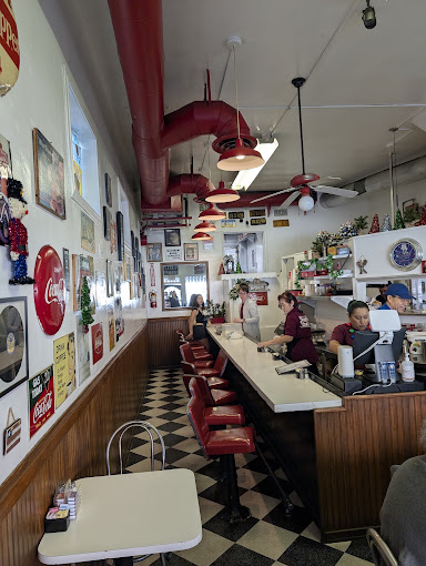 Inside Pop's Cafe: red pipe ceiling, checkerboard floor, and the counter
