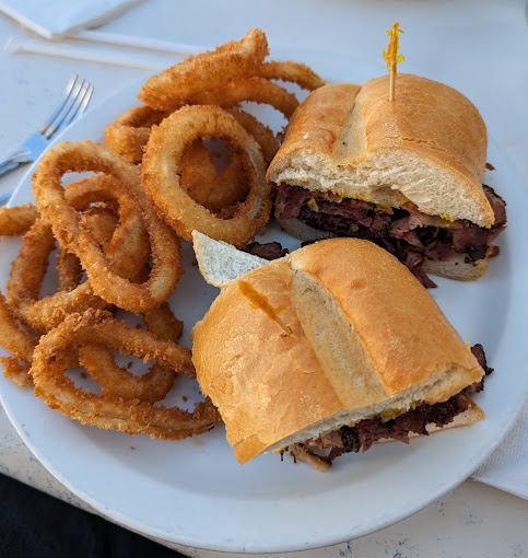 A pastrami melt on rye with onion rings